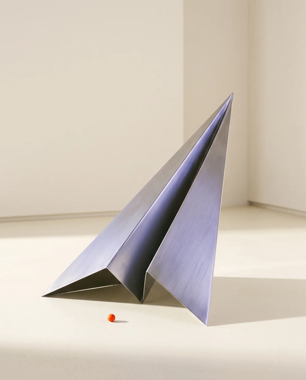 Sculptură conceptuală: o aripă metalică ascendentă, cu reflexe violet